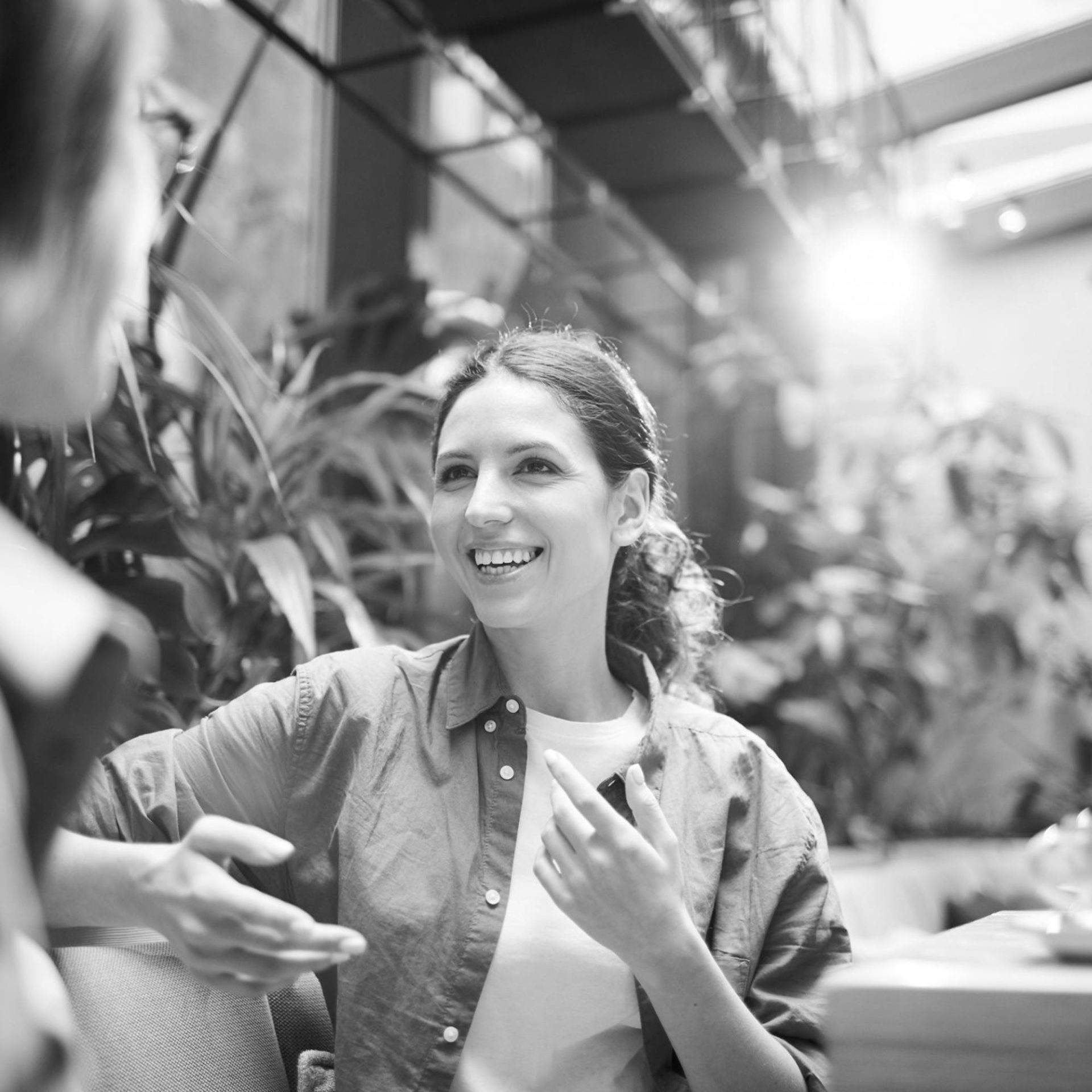 a woman smiles as she gestures with her hands