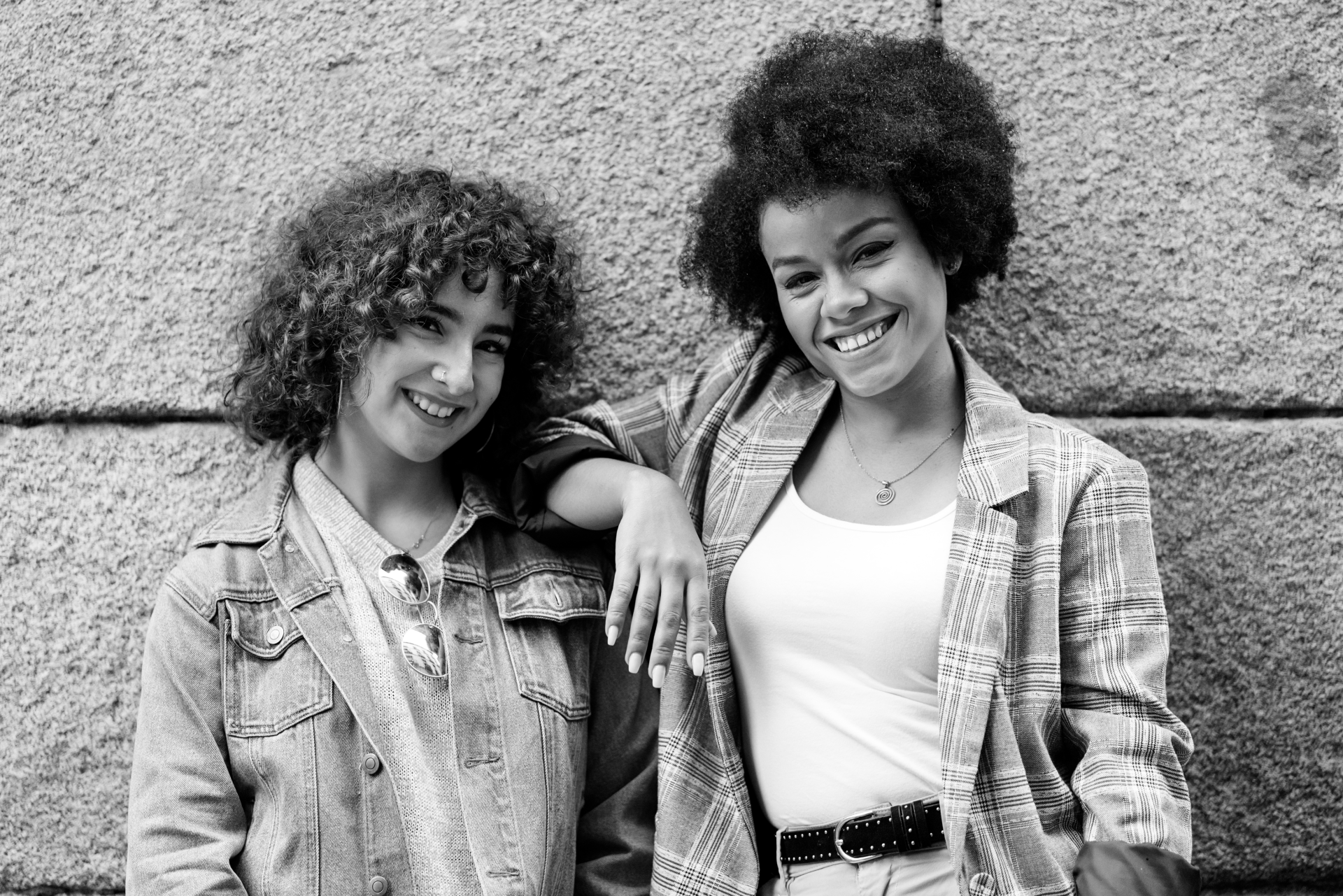 two women stand next to each other, smiling at the viewer