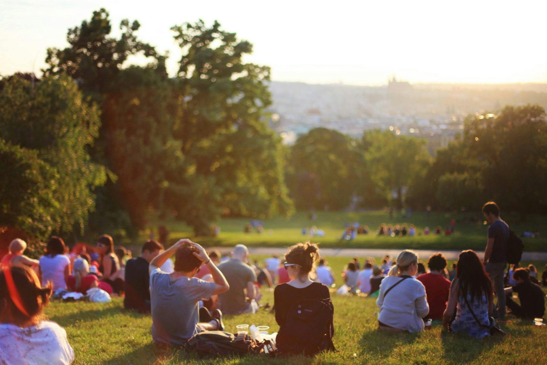 people sit on the ground in a park