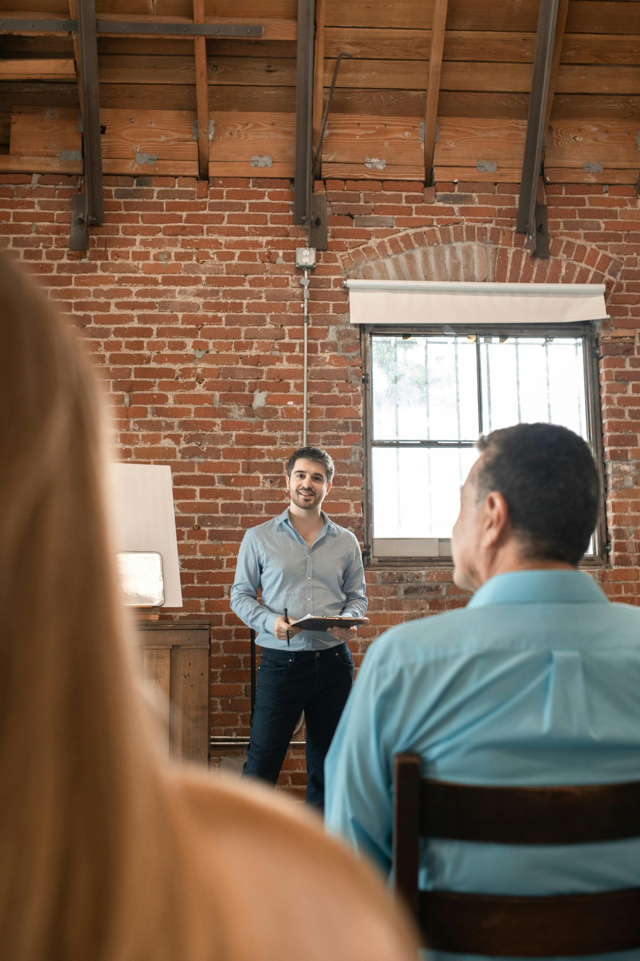 a man stands and speaks to a room of people